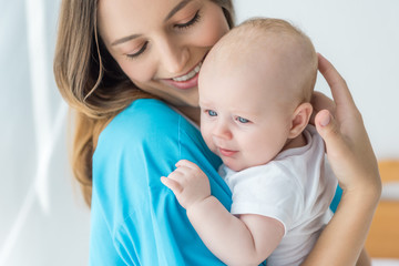 attractive and young mother holding her child in hospital