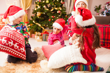 Kids hold hands battle pillow, floor time at Chrismtas