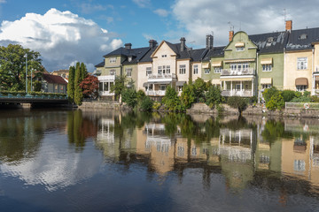 Fototapeta na wymiar Multicolored houses are reflected in the river. The city of Orebro in Sweden. Travel photo. Background photo.