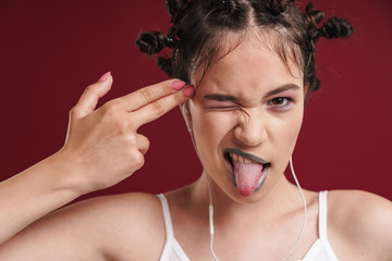 Teenage girl listening music showing gun gesture