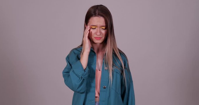 Upset teenage girl crying on light grey background