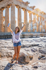 Junge, attraktive Touristin nimmt Selfie Fotos von sich vor der Akropolis von Athen auf,...