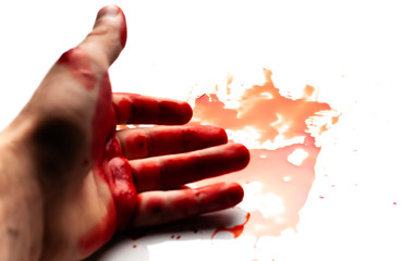 Male bloodied hand on a white background with splashes and drops of blood.