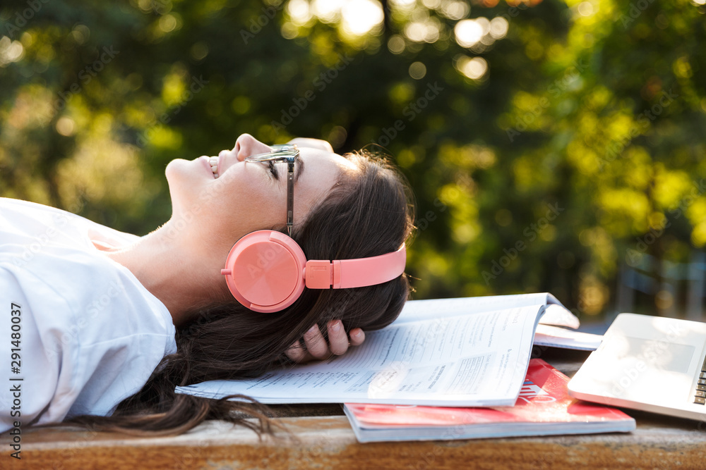 Sticker Lady outdoors listening music with headphones on copybooks.