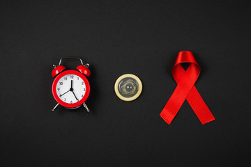 AIDS ribbon with condom on black background