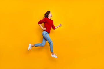 Obraz na płótnie Canvas Full length photo of funny lady jumping high rushing shopping wear knitted pullover isolated yellow background