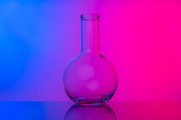 Chemical glassware close up on neon pink-purple background