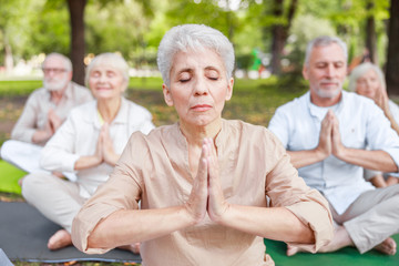 Mature people doing qigong meditation exercise outdoors