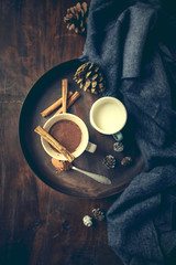 Hot chocolate, milk and cinnamon sticks on rustic tray. Flat lay. Still life