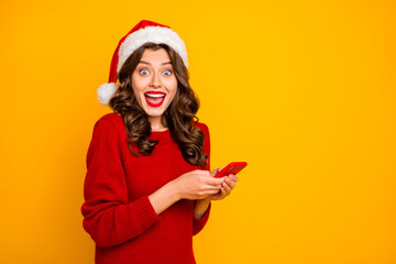 Photo of crazy lady holding telephone in hands wear knitted pullover and santa hat isolated yellow background