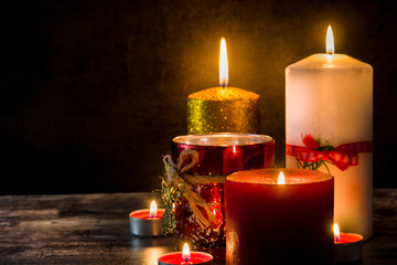 Christmas candles on wooden table and black background. Copy space