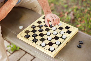 Mature man playing checkers on the street