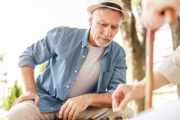Senior man playing checkers with his friend outdoors