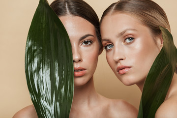 Women posing with green nature leaf plant. - obrazy, fototapety, plakaty