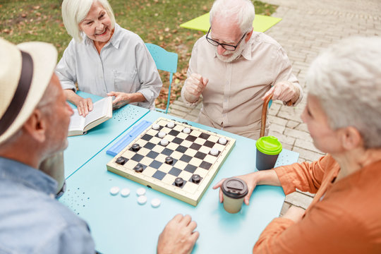 Old Men Playing Checkers With Friends In The Park