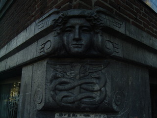 Stone head on corner of building with snake symbol