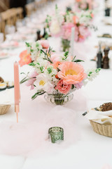 A small elegant bouquet of an assortment of fresh flowers adorns the dining table at the wedding