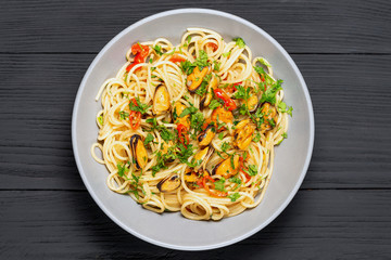 Pasta Spaghetti seafood with mussels Marinara, Typical dish of Italian pasta. top view. on a black background with a place for text, copy space