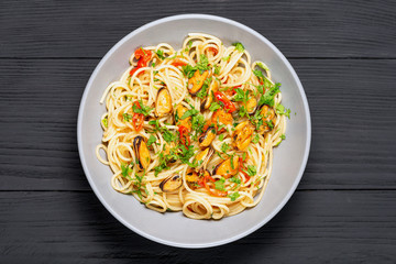 Pasta Spaghetti seafood with mussels Marinara, Typical dish of Italian pasta. top view. on a black background with a place for text, copy space