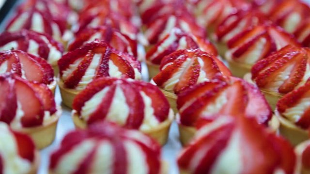 Cook Making A Row Of Vanilla And Strawberry Mini Tarts For A Sweet Buffet