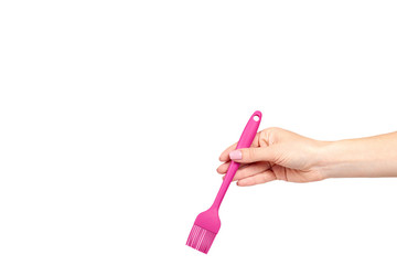 Hand with pink culinary brush, kitchen utensil.