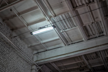 the ceiling of an industrial building with lighting in one lamp, photo from bottom to top