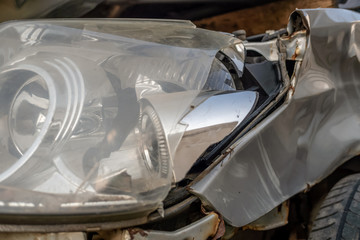 Car accident or accident. The left headlight of the gray car is broken. The broken parts of the car closeup.