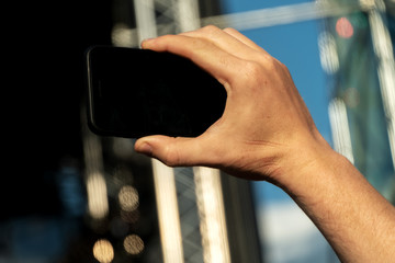 Obraz premium Hand holding a smartphone with a black screen and takes a close-up of what is happening