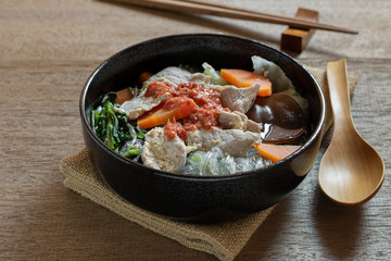 close up of pork sukiyaki in a ceramic bowl on wooden table. asian homemade style food concept.