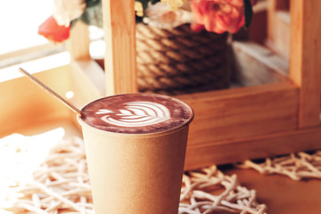 Cup of cappuccino with a pattern on a table in a cafe