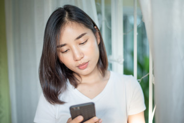 Obraz na płótnie Canvas Young woman use a smartphone at home.