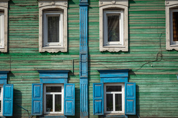 Window with the wooden carved architrave in the old wooden house in the old Russian town. Irkutsk