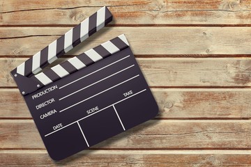 Clap board on wooden background top view