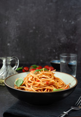 Spaghetti with tomato sauce on black background