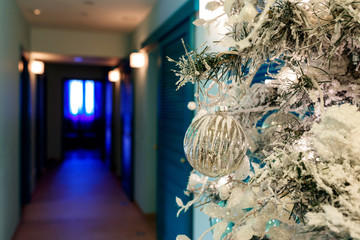 Christmas tree with white artificial snow on branches and decorations.