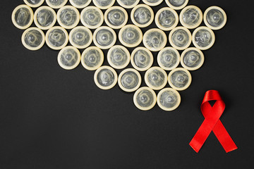 AIDS ribbon with condom on black background