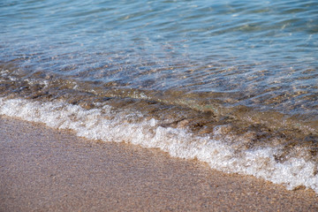 Fototapeta na wymiar Wave of the sea or ocean in the calm on the sandy coast