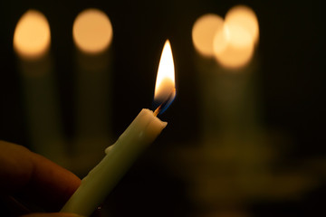 Close up hands  lighting candle vigil in darkness.Concept of light of hope., worship, prayer.soft...