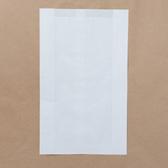 Mock-up of Recycled blank kraft paper shopping white bag for lunch or food or purchases on brown paper craft background