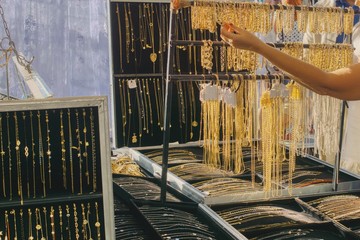 Obraz premium street sale of cheap jewelry at a market stall, local trade during the St. Francis fair, medals, pendants, chains