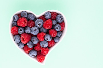 Creative layout made of Blueberry and raspberries on pastel background. Food ingredient pattern.