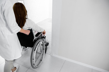 Nurse helping for female patient on wheelchair