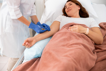 Obraz na płótnie Canvas Medic is making procedures for female patient