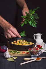 pan with meat in sauce with chili pepper on a dark background