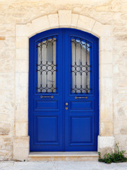 Fototapeta na wymiar Beautiful old door in dark blue. Fragment of the facade of a Sandstone house, Cyprus, Europe.