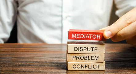 A man holds wooden blocks with the word Mediator, dispute, problem, conflict. Settlement of disputes by mediator. Dispute Resolution and Mediation. Third party, intermediary. - obrazy, fototapety, plakaty
