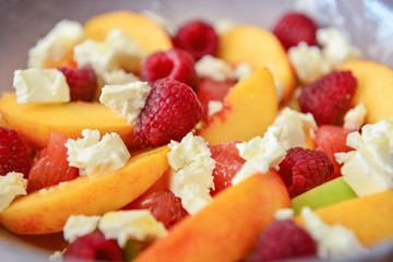 Tasty salad with peach and raspberry, closeup