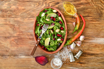 Plate with tasty salad on wooden table