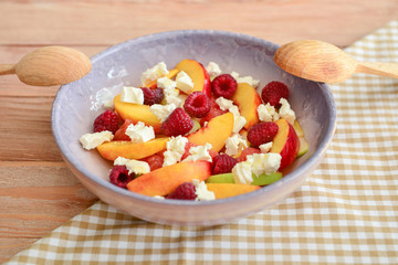 Plate with tasty salad on wooden table