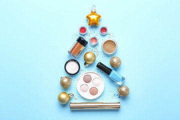 Set of cosmetics with decor in shape of Christmas tree on color background
